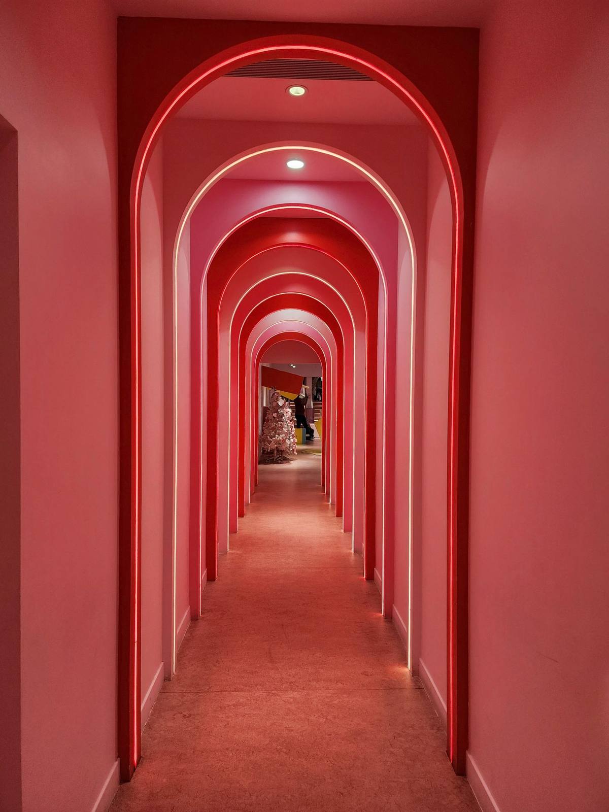 Corredor de arcos con neón magenta